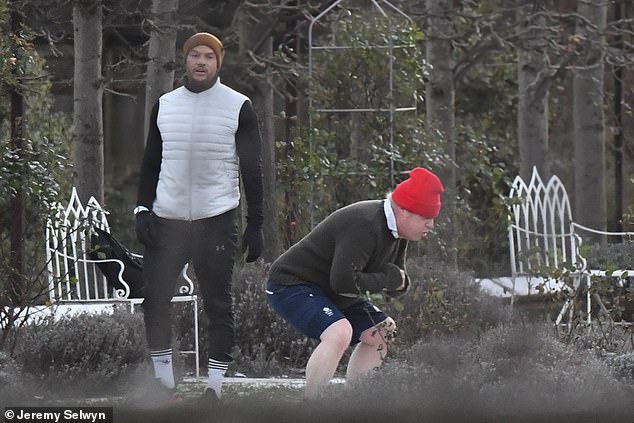 Beanie-wearing Boris Johnson braves the bitter chill for some squats and lunges