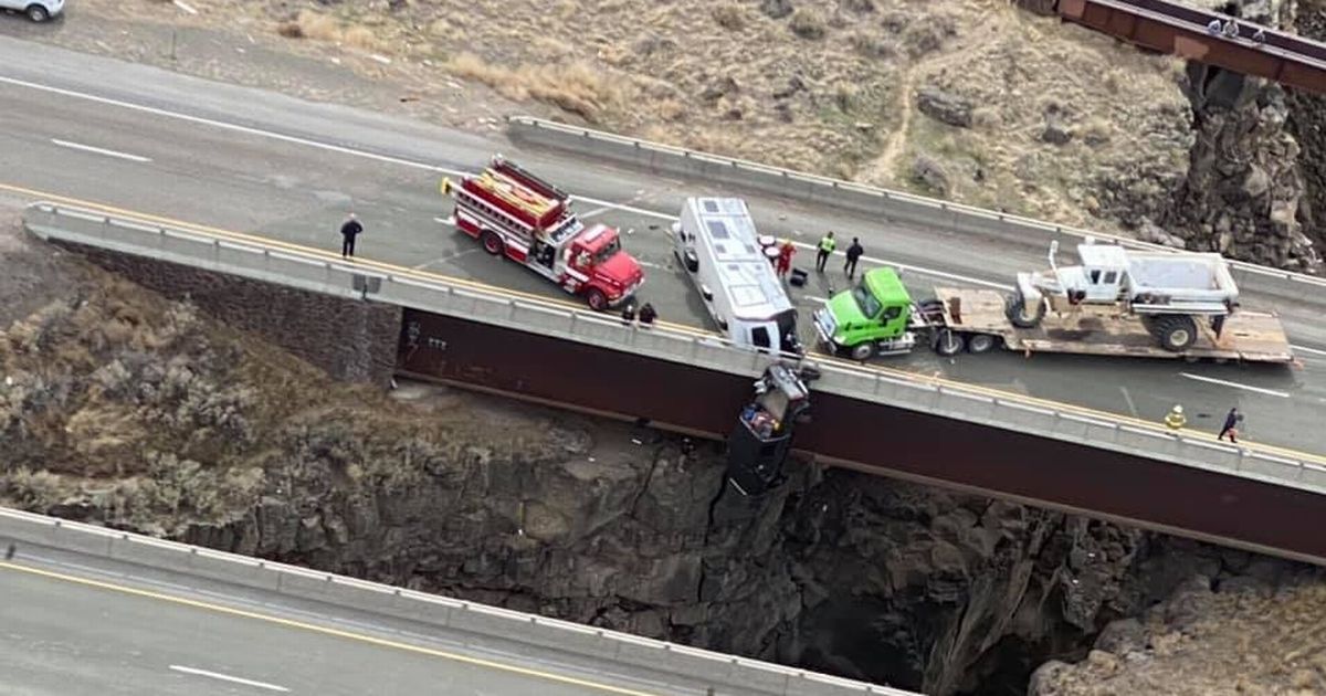 Terrifying moment couple rescued from car dangling over 100-foot drop on bridge